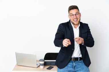 Beyaz arka planda izole edilmiş bir ofiste Rus bir adam ön tarafı işaret ediyor ve gülümsüyor.