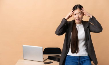 İş yerindeki Çinli iş kadını sürpriz bir ifadeyle