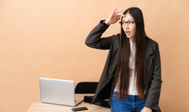 İş yerindeki Çinli iş kadını şaşırmış bir ifadeyle yan gözle bakarken