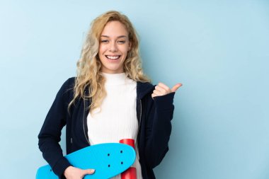 Mavi arka planda izole edilmiş genç, sarışın bir kadın.