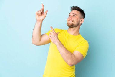 Rus yakışıklı adam mavi arka planda izole edilmiş işaret parmağıyla işaret etmek harika bir fikir.