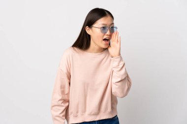 İzole edilmiş beyaz arka planda ağzı açık bir şekilde bağıran genç bir Çinli kız.