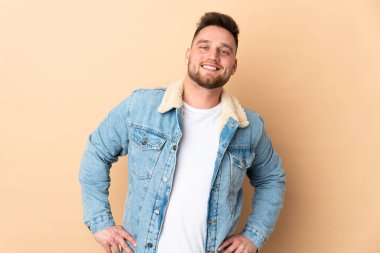 Rus yakışıklı adam izole edilmiş arka planda kolları kalçasında ve gülümsüyor.