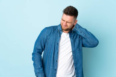 Mavi arka planda boynu ağrıyan Rus yakışıklı bir adam.