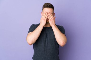 İzole edilmiş arka planda, gözleri elleriyle kaplayan Rus yakışıklı adam.