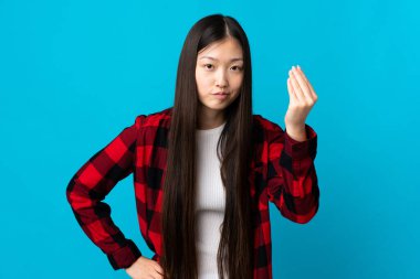 Genç Çinli kız izole edilmiş mavi arka planda İtalyan jestleri yapıyor.