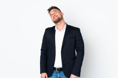 Genç Rus iş adamı beyaz arka planda izole edilmiş gülüyor ve yukarı bakıyor.