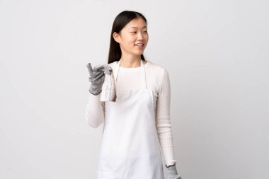 Çinli balıkçı önlük takıyor ve beyaz arka planda çiğ balık tutuyor.