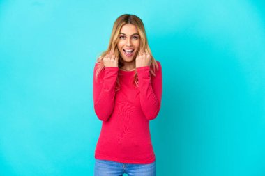 Soyutlanmış mavi arka planda zaferi kutlayan genç bir kadın.