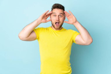 Mavi arka planda mahsur kalmış, şaşırmış Rus yakışıklı bir adam.