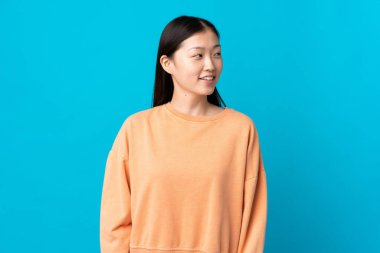 Soyutlanmış mavi arka plan görünümlü genç Çinli kız.