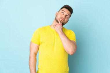 Mavi arka planda mahsur kalmış Rus yakışıklı adamın şüpheleri var.