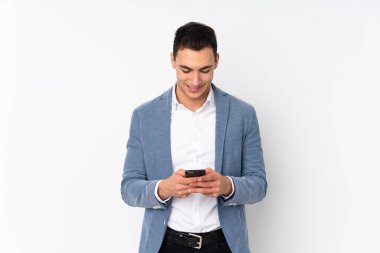 Tecrit edilmiş genç ve yakışıklı iş adamı cep telefonuyla mesaj gönderiyor.