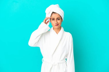 İzole edilmiş mavi arka planda bornozlu genç bir kadının şüpheleri vardı.