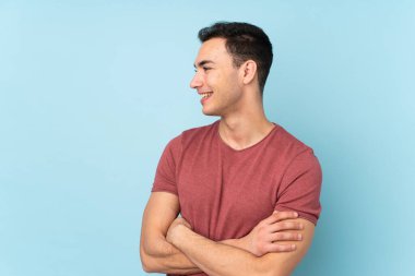 Beyaz tenli yakışıklı adam mavi arka planda izole edilmiş.