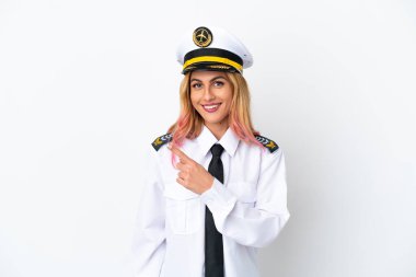 İzole edilmiş beyaz arka plan üzerinde uçak pilotu bir ürünü sunmak için kenarı işaret ediyor