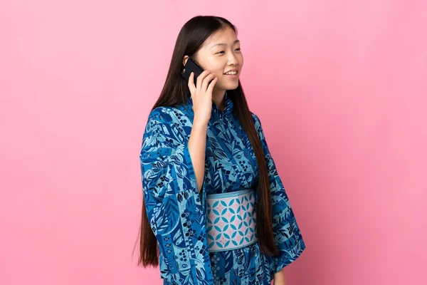 Joven Chica China Usando Kimono Sobre Fondo Aislado Manteniendo Una —  Fotos de Stock