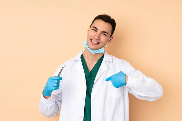 若い歯科医男保持ツール分離上ベージュ背景誇りと自己満足 — ストック写真