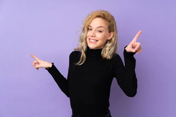 Молода Блондинка Ізольована Фіолетовому Фоні Вказуючи Пальцем Латеральні Щасливі — стокове фото
