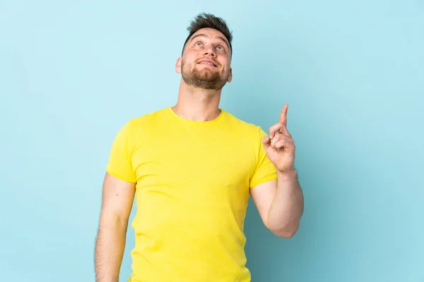 Hombre Guapo Ruso Aislado Sobre Fondo Azul Apuntando Hacia Arriba —  Fotos de Stock