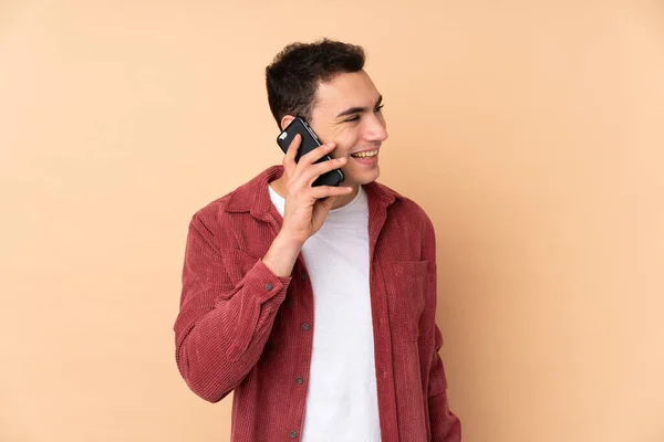 Young Caucasian Handsome Man Isolated Beige Background Keeping Conversation Mobile — Stock Photo, Image