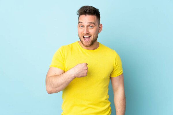 Russian handsome man isolated on blue background with surprise facial expression