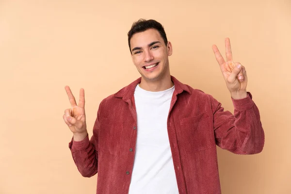 Young Caucasian Handsome Man Isolated Beige Background Showing Victory Sign — Stock Photo, Image