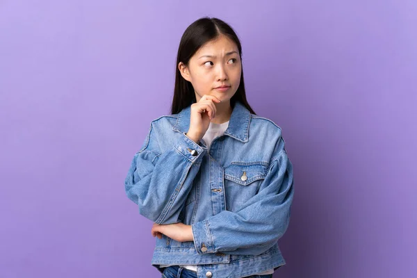 Ung Kinesisk Flicka Över Isolerade Lila Bakgrund Med Tvivel Och — Stockfoto