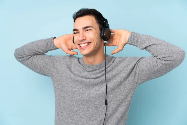 Νεαρός Καυκάσιος Όμορφος Άνδρας Απομονωμένος Μπλε Φόντο Ακούγοντας Μουσική — Φωτογραφία Αρχείου