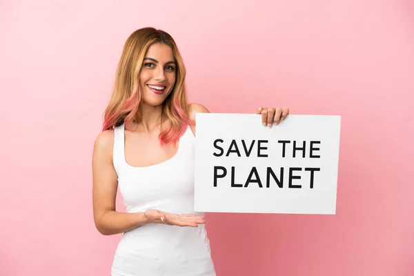 隔離されたピンクの背景の上の若い女性は テキストでプラカードを保持惑星を保存し それを指す — ストック写真