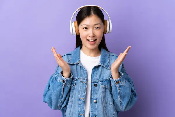 Joven Chica China Sobre Aislado Púrpura Fondo Sorprendido Escuchar Música — Foto de Stock
