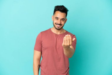 Kafkasyalı genç bir adam mavi arka planda izole edilmiş ve davet edilmişti. Gelmene sevindim.