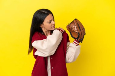 Beyzbol oynayan beyaz bir kadın, sarı arka planda izole edilmiş, çabaladığı için omuz ağrısı çekiyor.