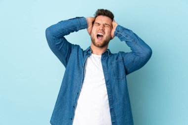 Mavi arka planda izole edilmiş Rus yakışıklı adam bunalmış durumda.