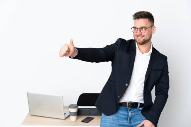Beyaz arka planda izole edilmiş bir ofiste Rus bir adam baş parmak işareti yapıyor.