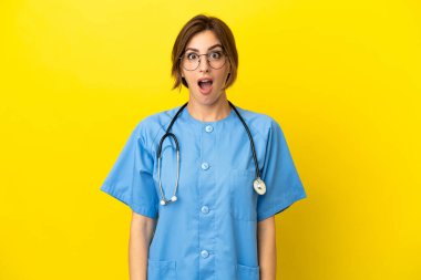 Doktor kadın, sarı arka planda şaşırmış bir yüz ifadesiyle izole edilmiş.