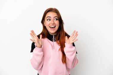 Genç kızıl saçlı kadın, beyaz arka planda izole edilmiş ve yüzünde sürpriz bir ifade var.