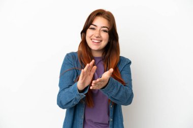 Beyaz arka planda izole edilmiş genç kızıl saçlı kadın bir konferanstan sonra alkışlıyor.