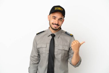 Beyaz arka planda izole edilmiş genç bir beyaz adam bir ürün sunmak için kenarı işaret ediyor.