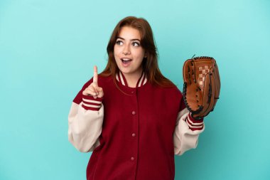 Beyzbol oynayan genç kızıl saçlı kadın, mavi arka planda soyutlanmış bir şekilde, bir fikrin parmağı yukarı kaldırdığını düşünüyor.