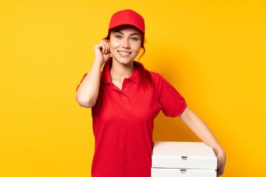 Pizza dağıtan kız arka planda pizza tutuyor ve gülüyor.