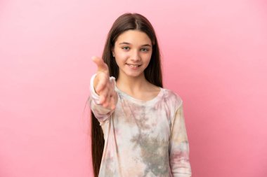 Pembe arka planda küçük bir kız iyi bir anlaşma için el sıkışıyor.