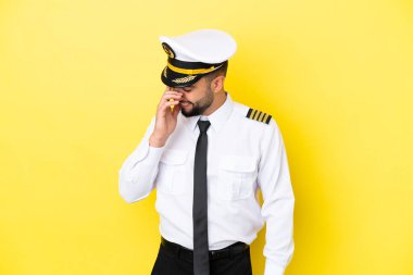 Arap uçak pilotu, sarı arka planda izole edilmiş kahkaha atıyor.