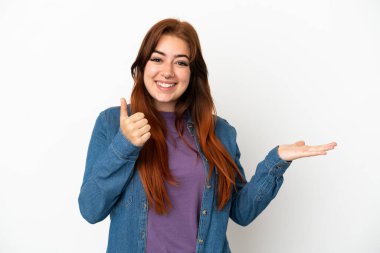 Beyaz arka planda izole edilmiş genç, kızıl saçlı bir kadın. Avucunun içinde hayali bir şey tutuyor. Bir ilan vermek için.