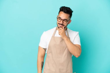 Restoran garsonu Kafkasyalı adam mavi arka planda izole edilmiş.