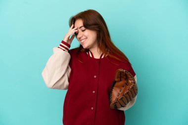 Beyzbol oynayan genç kızıl saçlı kadın mavi arka planda izole edilmiş gülüyor.