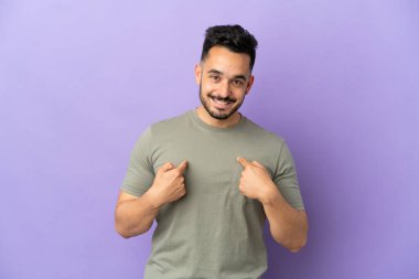 Mor arka planda yüzü sürpriz bir ifadeyle izole edilmiş genç beyaz bir adam.