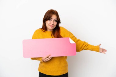 Genç kızıl saçlı kadın beyaz arka planda izole edilmiş, elinde boş bir levha var ve şüpheleri var.