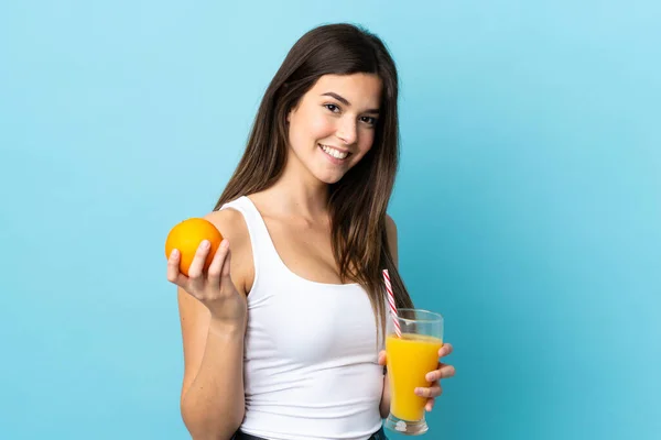 Adolescente Brasileña Sobre Fondo Azul Aislado Sosteniendo Una Naranja Jugo — Foto de Stock