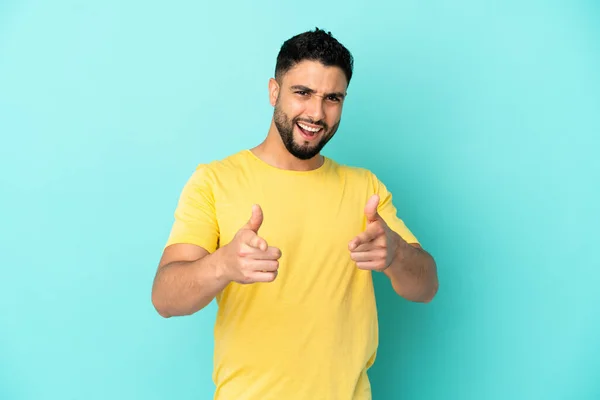 Jonge Arabische Man Geïsoleerd Blauwe Achtergrond Wijzend Naar Voorkant Glimlachend — Stockfoto